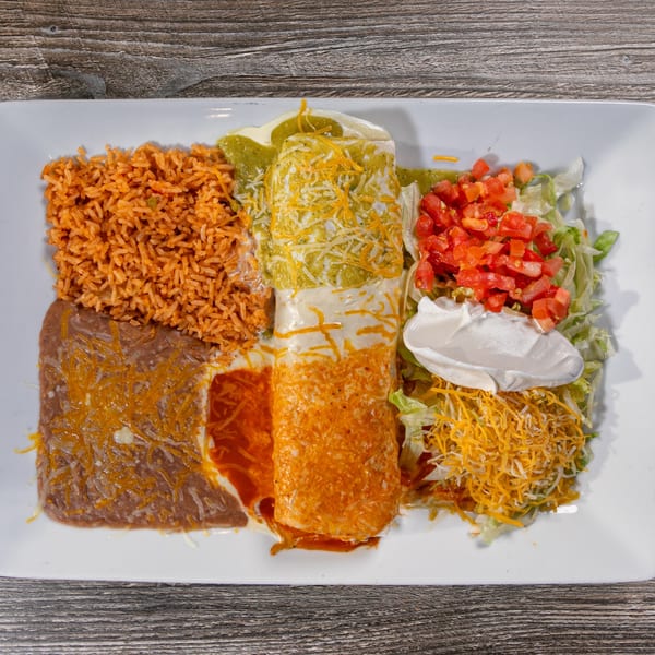 A large Mexican combination plate with rice, refried beans, two enchiladas, and a side salad.