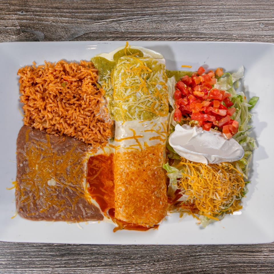 A large Mexican combination plate with rice, refried beans, two enchiladas, and a side salad.