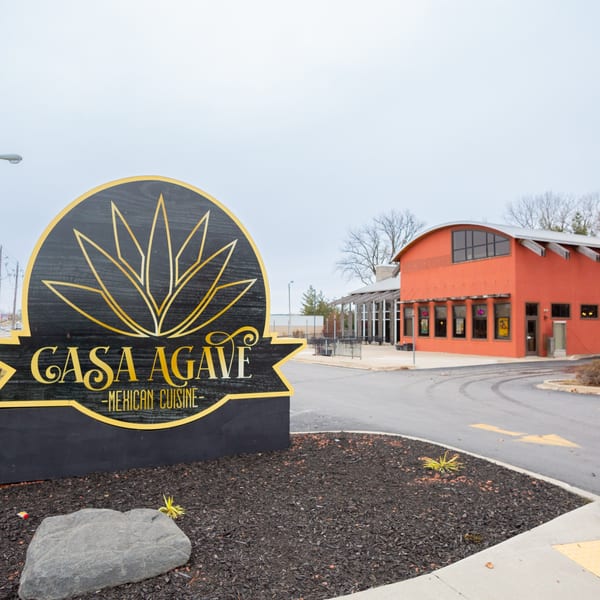 Casa Agave Mexican Cuisine sign in front of the orange restaurant building and parking lot.