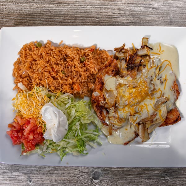 Casa Agave's Mexican dish with rice, grilled chicken, onions, cheese sauce, lettuce, tomatoes, and sour cream.